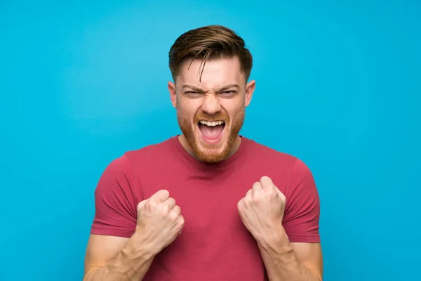 Redhead Man Geïsoleerde Blauwe Muur Vieren Een Overwinning — Stockfoto