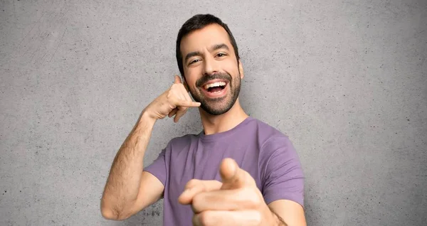 Handsome Man Making Phone Gesture Pointing Front Textured Wall — Stock Photo, Image