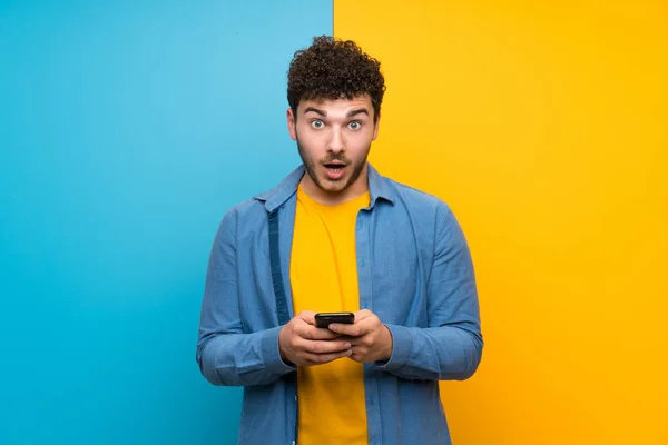 Man Curly Hair Colorful Wall Surprised Sending Message — Stock Photo, Image