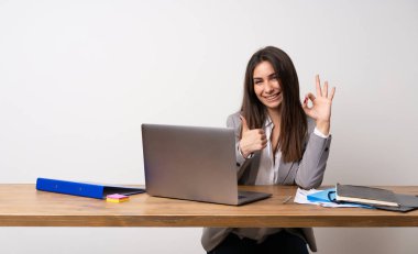 Bir ofiste iş kadını ile ok işareti gösteren ve jest kadar bir başparmak veren