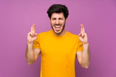 Parmakları geçiş ile izole mor duvar üzerinde Yakışıklı