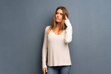 Sarışın kadın intihar jest yapma sorunları olan gri arka plan üzerinde