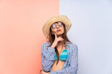 Bikinili genç bir kadın bir fikir düşünüyor.