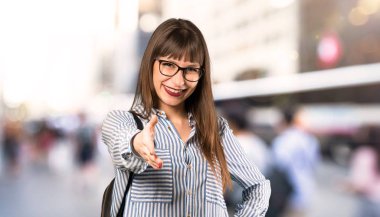 Açık havada iyi bir anlaşma kapanış için eller sallayarak gözlük kadın