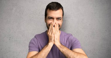 Dokulu duvar üzerinde ağız kapsayan yakışıklı adam çok gülümsüyor