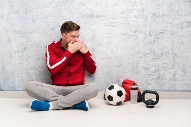 Redhead spor adam ağız kapsayan ve yan bakıyor