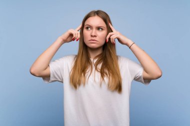 Mavi duvarın ardındaki genç kadının şüpheleri ve düşünceleri var.