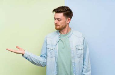 Şüphelerle copyspace tutan renkli arka plan üzerinde Redhead adam