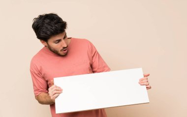 Yakışıklı adam bir kavram eklemek için boş bir beyaz pankart tutan