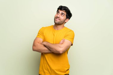 Gülümseyen süre pembe duvar üzerinde genç adam bakıyor