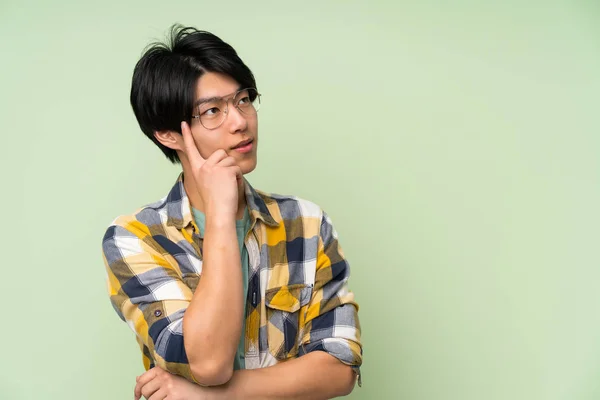 Asiatisk Man Över Isolerad Grön Vägg Med Glasögon — Stockfoto