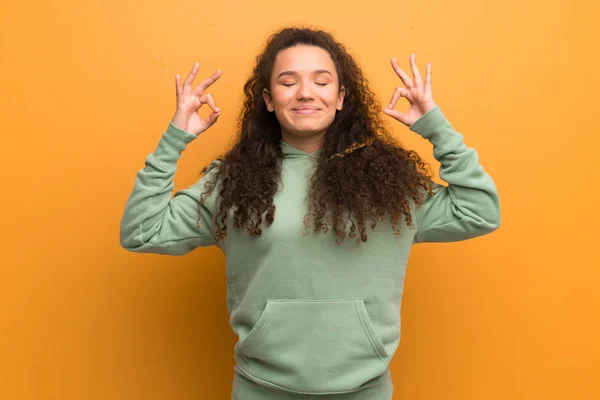 Teenager girl over ocher wall in zen pose