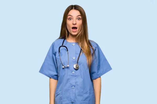 Young Nurse Surprise Shocked Facial Expression Isolated Blue Background — 스톡 사진