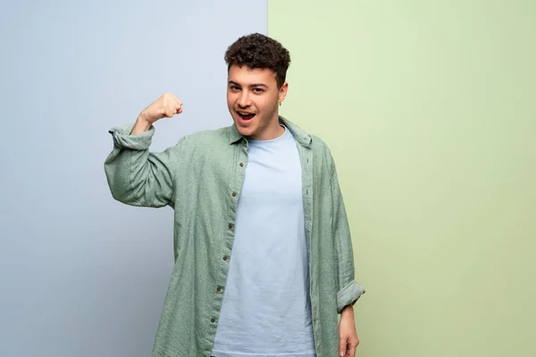 Junger Mann Über Blauem Und Grünem Hintergrund Stolz Und Selbstzufrieden — Stockfoto