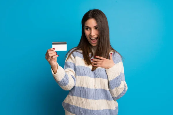 Jonge Vrouw Blauwe Muur Met Een Creditcard Verrast — Stockfoto