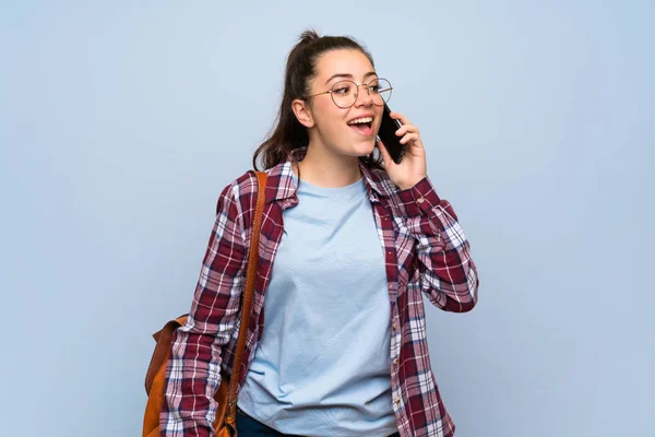 Tiener Student Meisje Geïsoleerde Blauwe Muur Een Gesprek Met Mobiele — Stockfoto