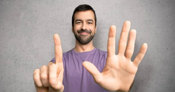 Hombre Guapo Contando Seis Con Dedos Sobre Pared Texturizada —  Fotos de Stock