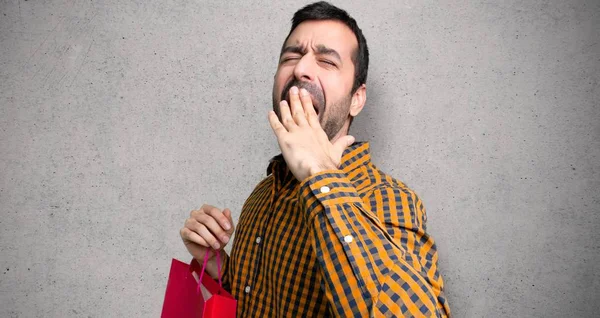 Człowiek Torby Zakupy Ziewanie Obejmujące Szeroko Otwarte Usta Ręki Teksturowanej — Zdjęcie stockowe
