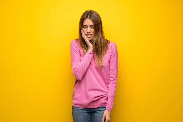 女性とともにピンクセーター以上黄色の壁に歯痛 — ストック写真