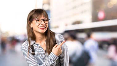 Açık havada bir ürün sunmak için yan işaret gözlük ile kadın