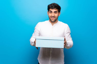 Genç adam mavi duvarı aştı. Şaşırdı çünkü ona bir hediye verildi.