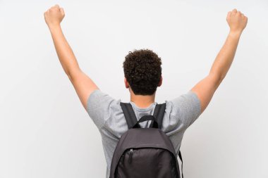 Sırt çantası ile izole duvar üzerinde kıvırcık saçlı Adam