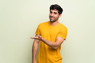 Genç adam pembe duvarın üzerinden gülümserken bir fikir sunuyor.