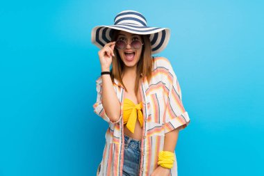 Yaz tatilinde bikinili genç bir kadın gözlüklü ve şaşırmış.