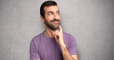 Dokulu duvara bakarken bir fikir düşünen yakışıklı adam