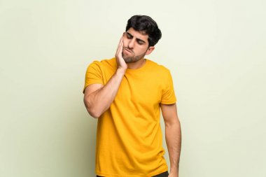 Diş ağrısı ile pembe duvarın üzerinden genç adam