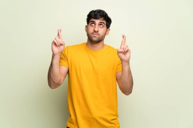 Parmak geçiş ve en iyi isteyen ile pembe duvar üzerinde genç adam