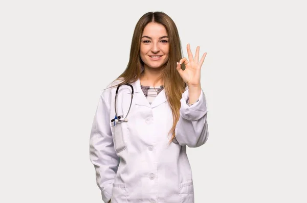 Νεαρή Γιατρός Γυναίκα Δείχνει Ένα Σημάδι Δάχτυλα Απομονωμένο Γκρι Φόντο — Φωτογραφία Αρχείου