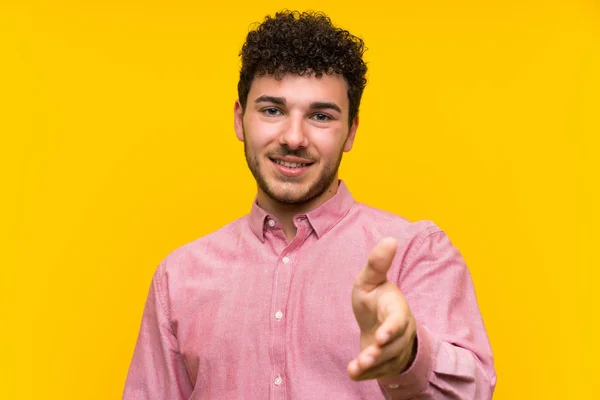 Man Curly Hair Isolated Yellow Wall Handshaking Good Deal — Stock Photo, Image