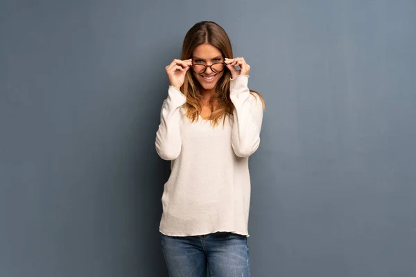 Mujer Rubia Sobre Fondo Gris Con Gafas Sorprendida — Foto de Stock