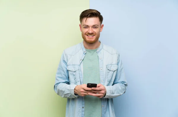 Ruda Człowiek Kolorowym Tle Wysyłając Wiadomość Telefonem — Zdjęcie stockowe