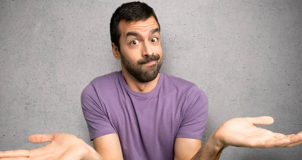 Bonito Homem Com Dúvidas Levantar Mãos Ombros Sobre Parede Texturizada — Fotografia de Stock