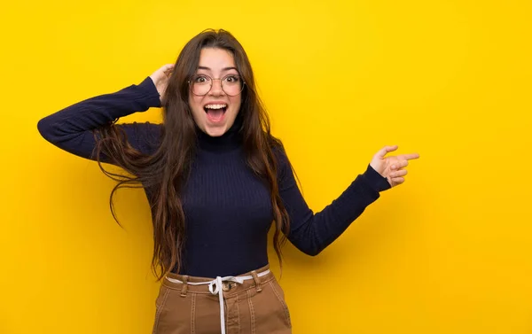 Dívka Pubertě Přes Izolovanou Žlutou Zeď Překvapila Ukázala Prstem Stranu — Stock fotografie
