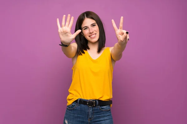 7本指で数える隔離された紫色の壁の上に若い女性 — ストック写真