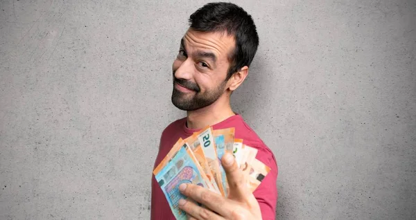 İnsan dokulu duvar üzerinde emin bir ifade ile para puan parmağı çok alarak