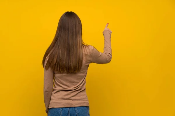 Ung Kvinna Över Färgglada Bakgrund Pekar Tillbaka Med Pekfingret — Stockfoto