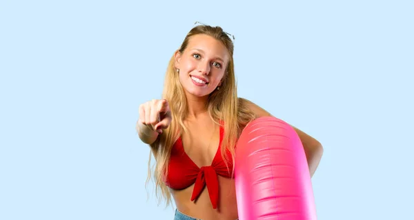 青い背景に正面を指す夏休みのブロンドの女性 — ストック写真