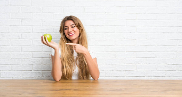 Happy Young blonde woman with an apple