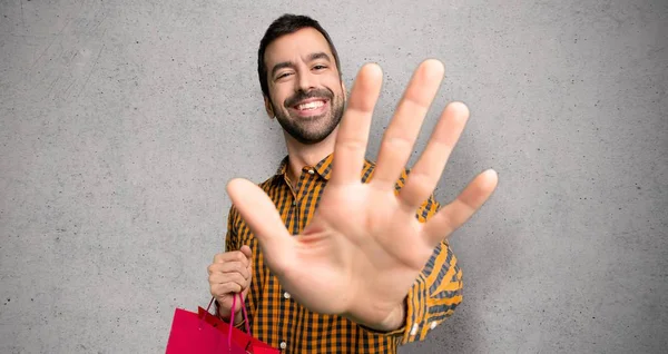 Hombre Con Bolsas Compras Contando Cinco Con Dedos Sobre Pared — Foto de Stock