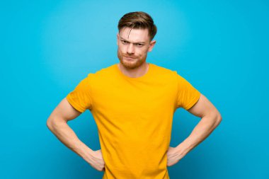 Mavi duvar üzerinde Redhead adam kızgın