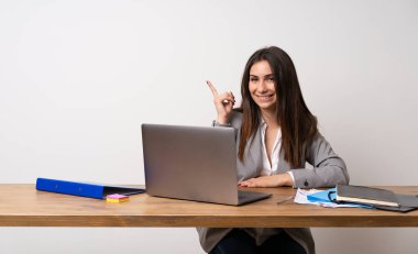 İş kadını bir ofiste gösteren ve en iyi işareti bir parmak kaldırma