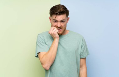 Renkli arka plan sinirli ve korkmuş üzerinde Redhead adam