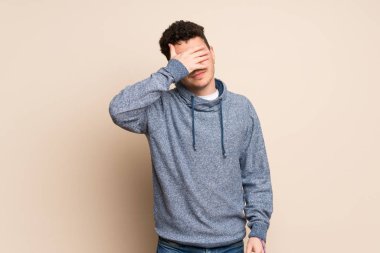 İzole edilmiş duvarın üzerindeki genç adam elleriyle gözlerini kapatıyor. Bir şey görmek istemiyorum.