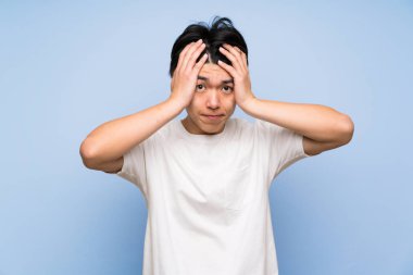 Sürpriz yüz ifadesi ile izole mavi arka plan Asyalı adam