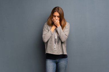 Gri arka plan üzerinde sarışın kadın öksürük ile acı ve kötü hissediyor