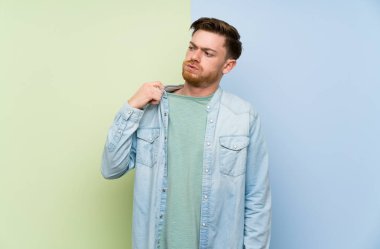 Yorgun ve hasta ifade ile renkli arka plan üzerinde Redhead adam